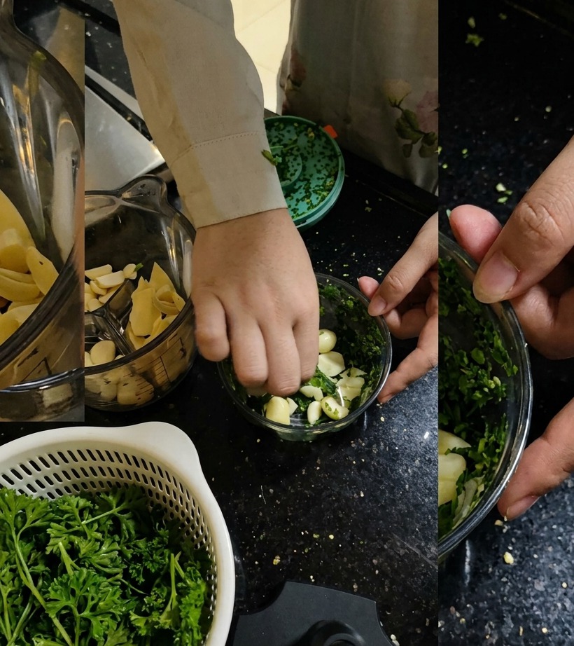 Fresh parsley being added into the food processor with garlic cloves.