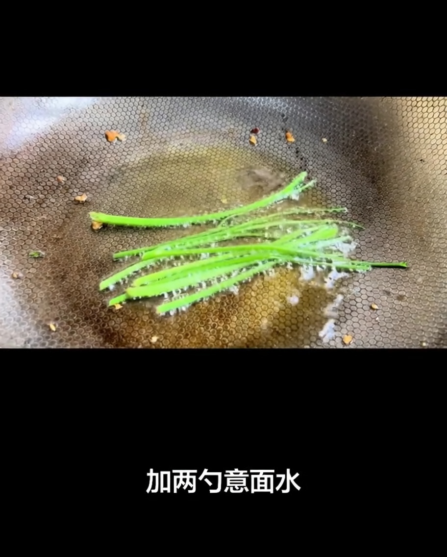 Pasta water being poured into the hot wok, creating a bubbling sauce base.