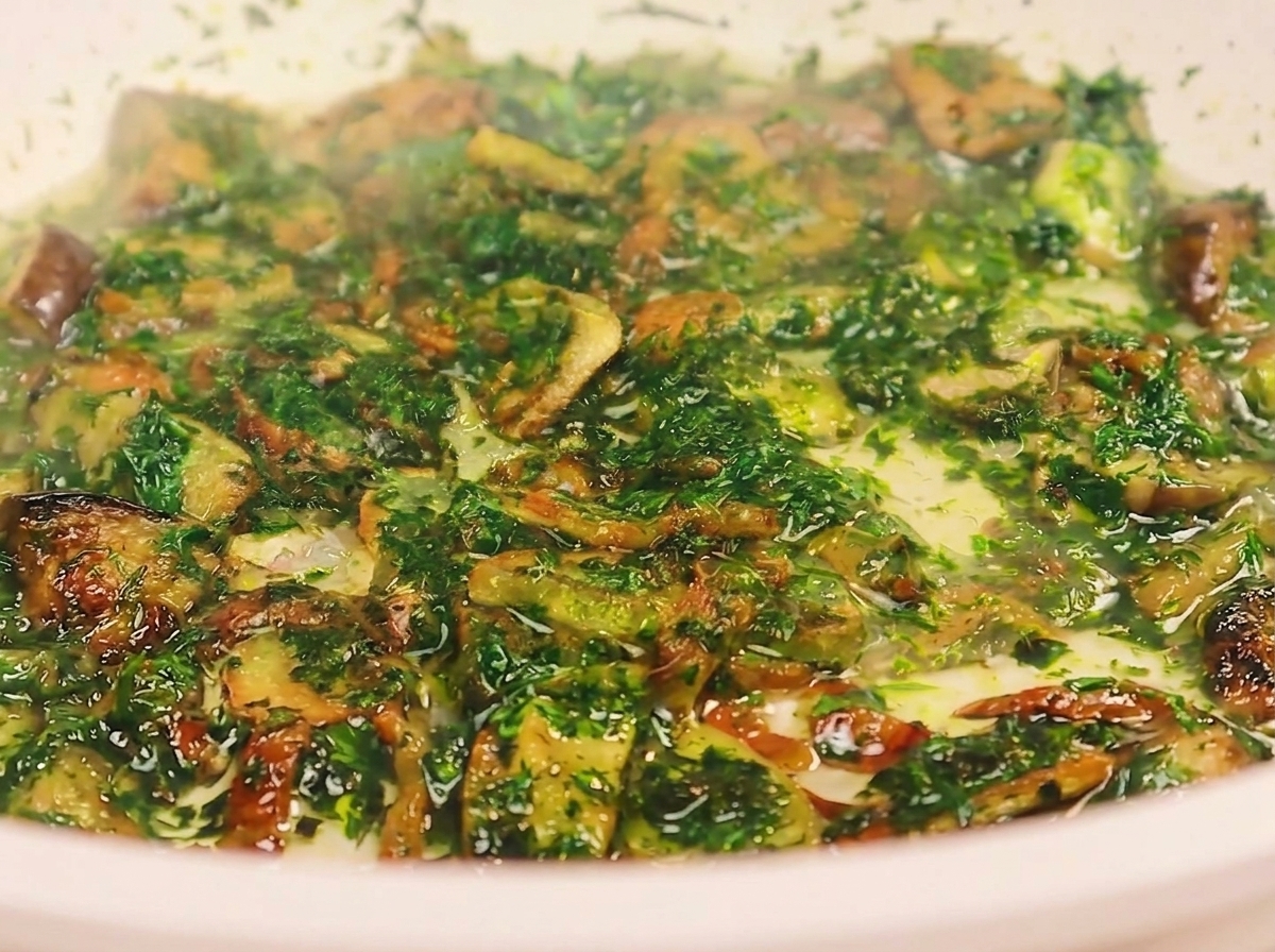 A ladle pouring cloudy pasta water into a pan containing fried bacon, garlic, and chopped parsley.