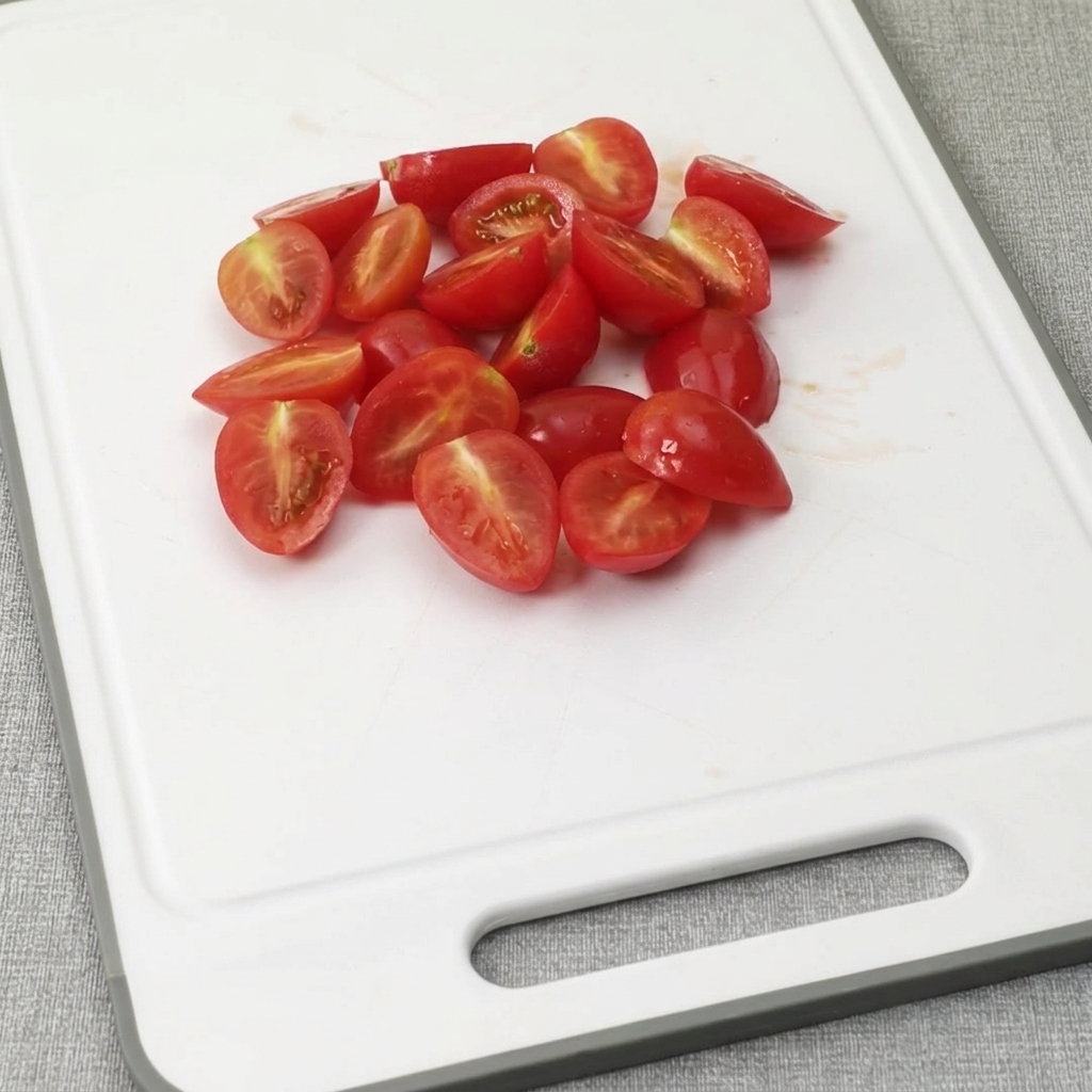 Bacon strips being cut into small pieces on a white plastic cutting board.