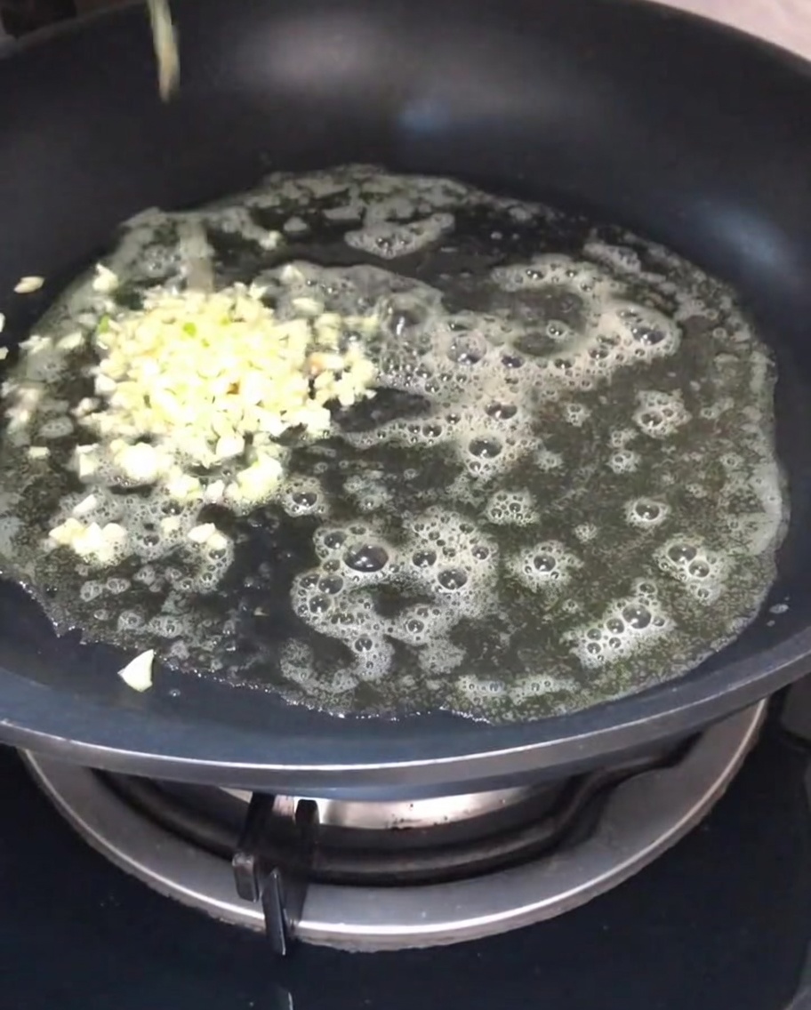 Minced garlic sautéing in melted butter in a pan.