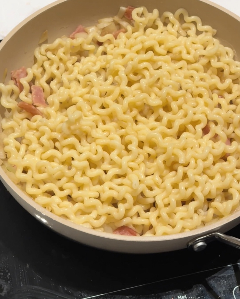 Low-fat milk being poured over the noodles in the pan.