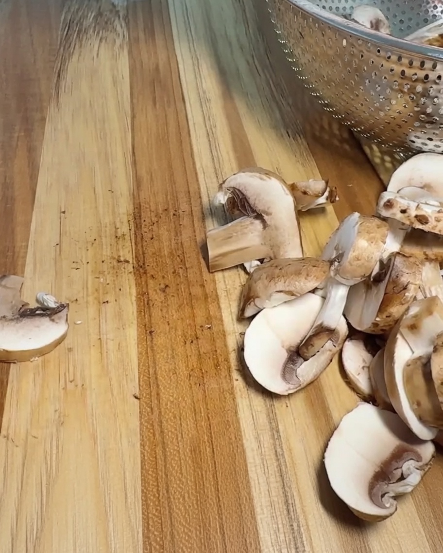 An onion being carefully cut into uniform chunks on a wooden cutting board.