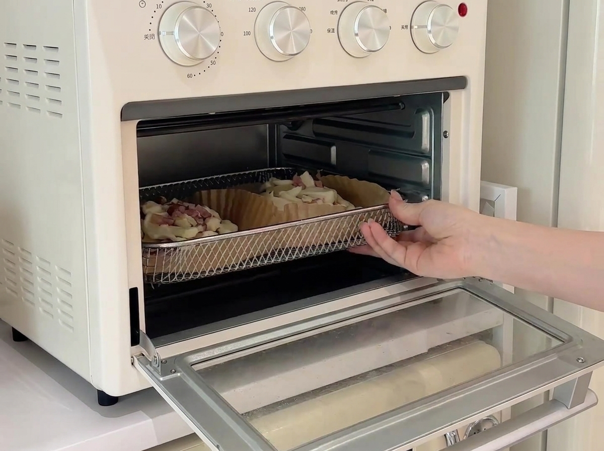Two mini pizzas on a wire rack inside a small white countertop oven, currently baking.
