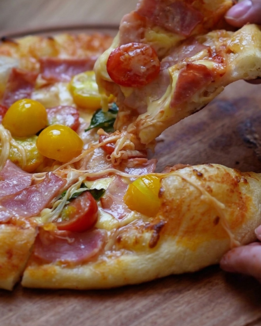 Hands pressing down on a round piece of pizza dough to shape it, creating a thin center and a defined, thicker crust edge.