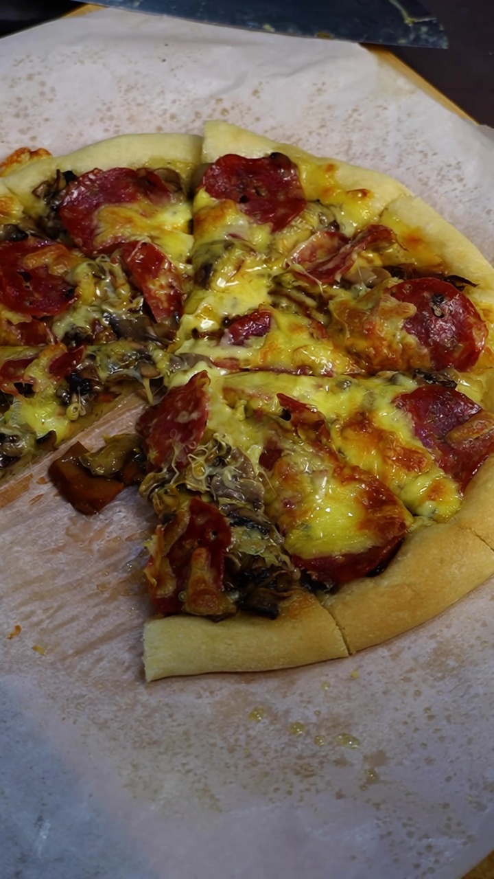 A freshly baked homemade pizza loaded with melted cheese, roasted mushrooms, and pepperoni slices.
