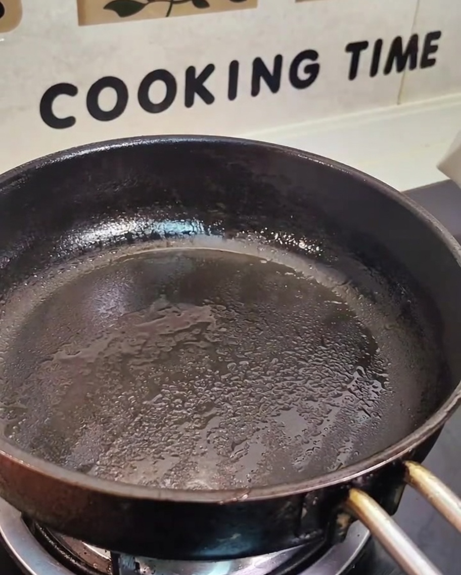 Slices of Chashu pork browning in a skillet.