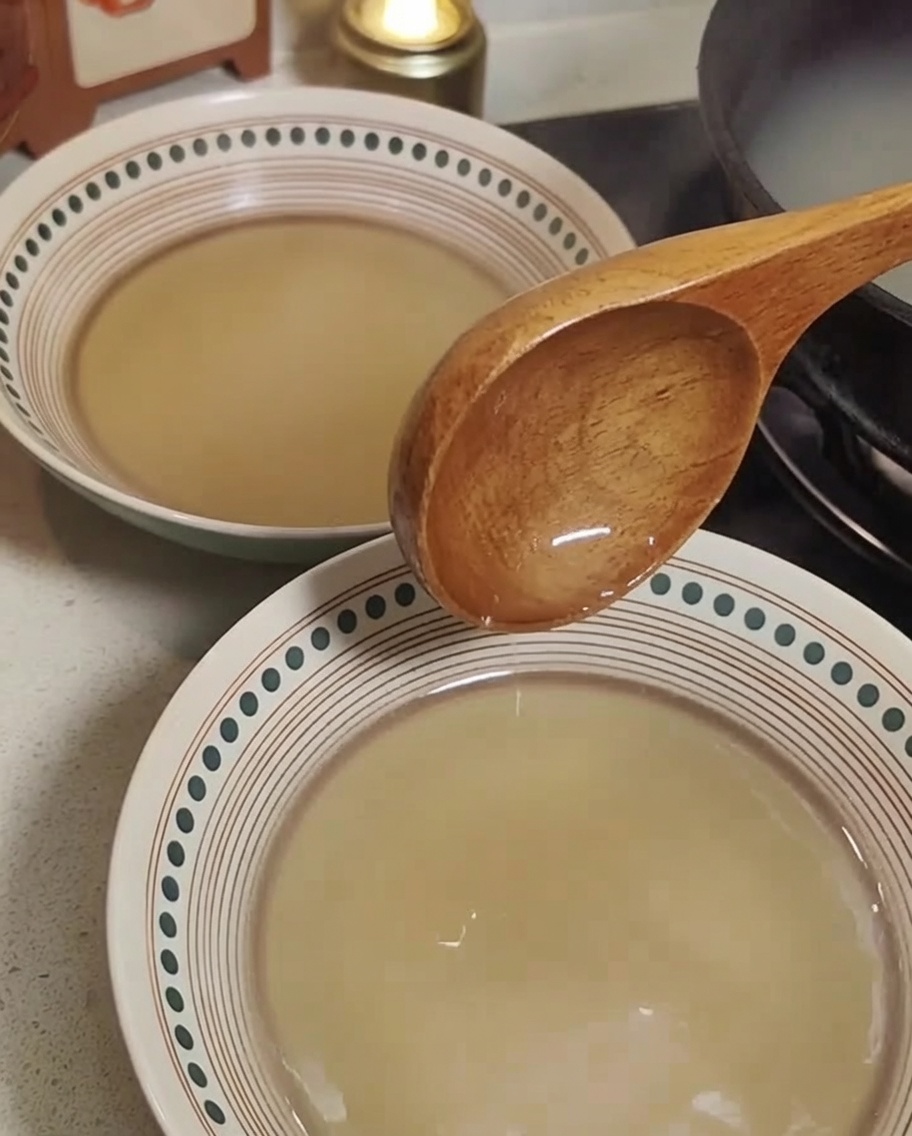 Cooked ramen noodles being added to bowls of prepared ramen broth.