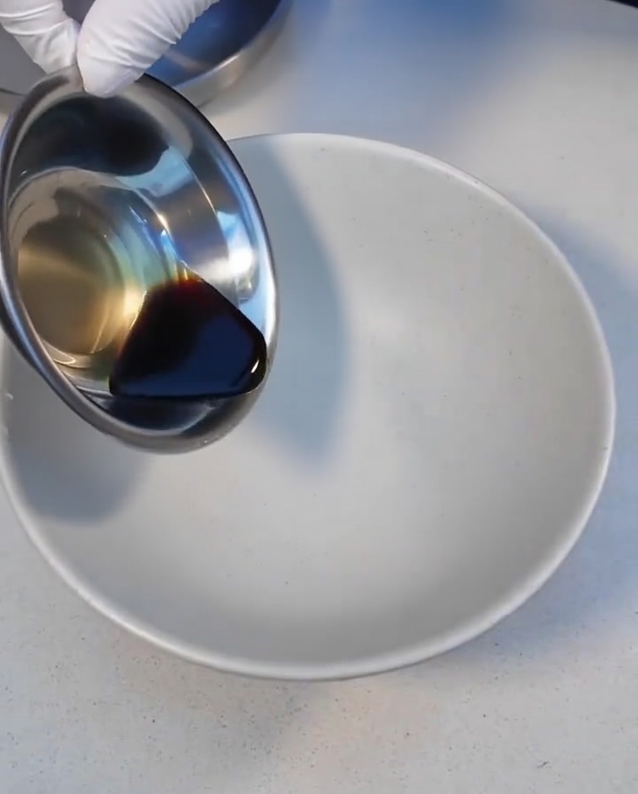 Dark Char Siu sauce being poured into a white serving bowl.