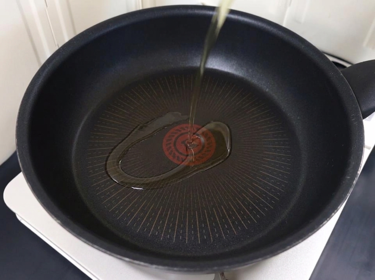 Thinly sliced pork browning in a pan with hot oil.