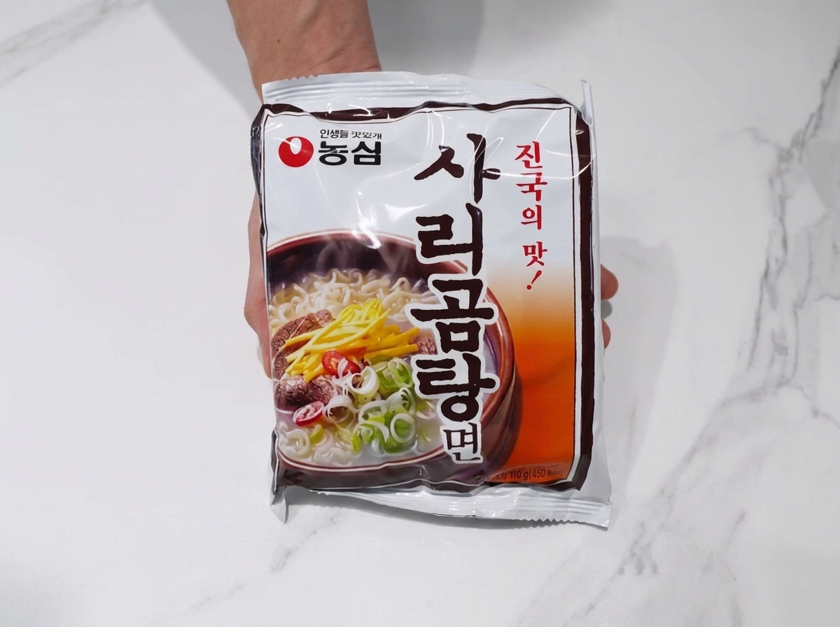 A block of ramen noodles added to the boiling pork and kimchi broth.