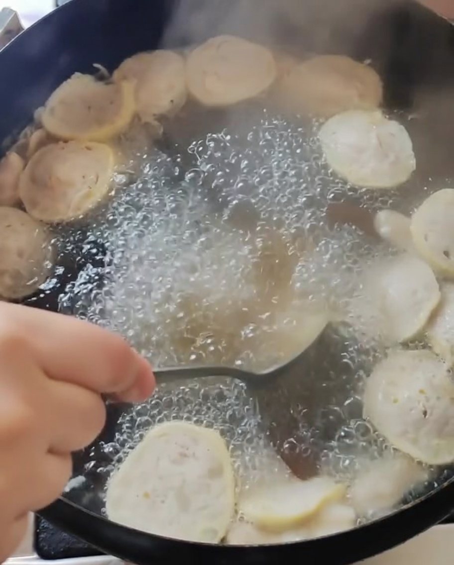 Soup being stirred in the main pot after seasoning.