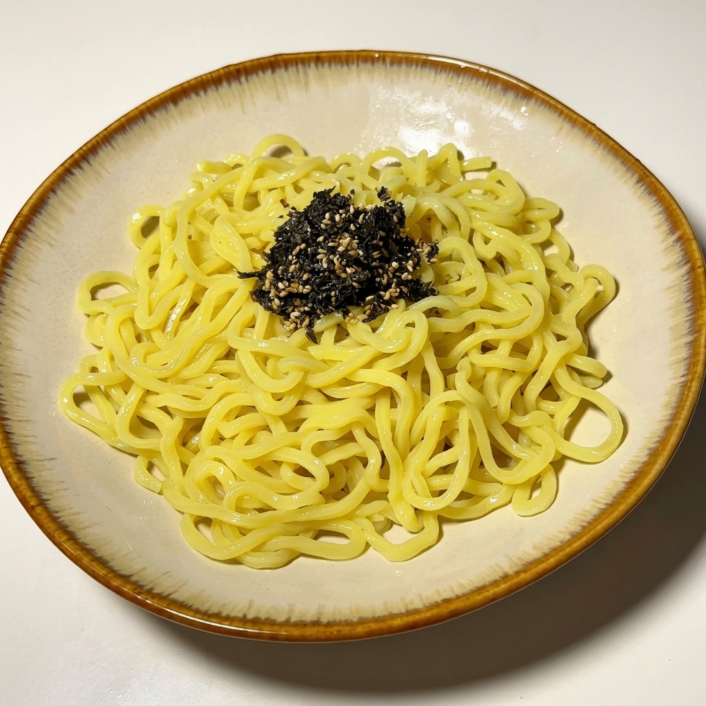Cooked noodles in a bowl garnished with black sesame seeds and chopped scallions.