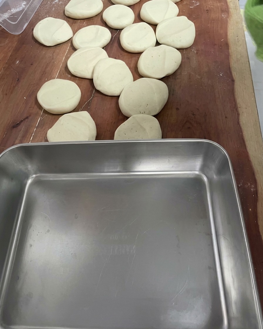 Several small, uniform pieces of dough arranged on a wooden surface.