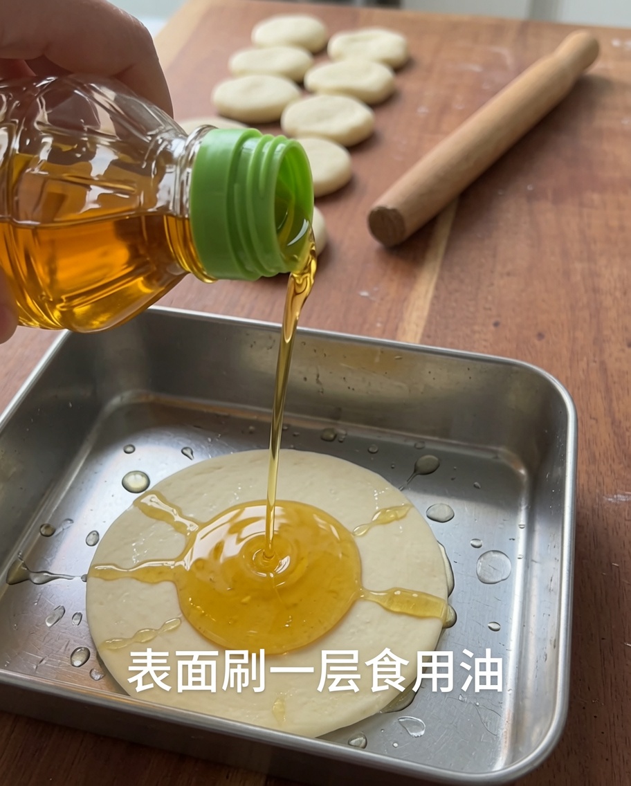 Cooking oil being poured over a piece of dough in a metal container.