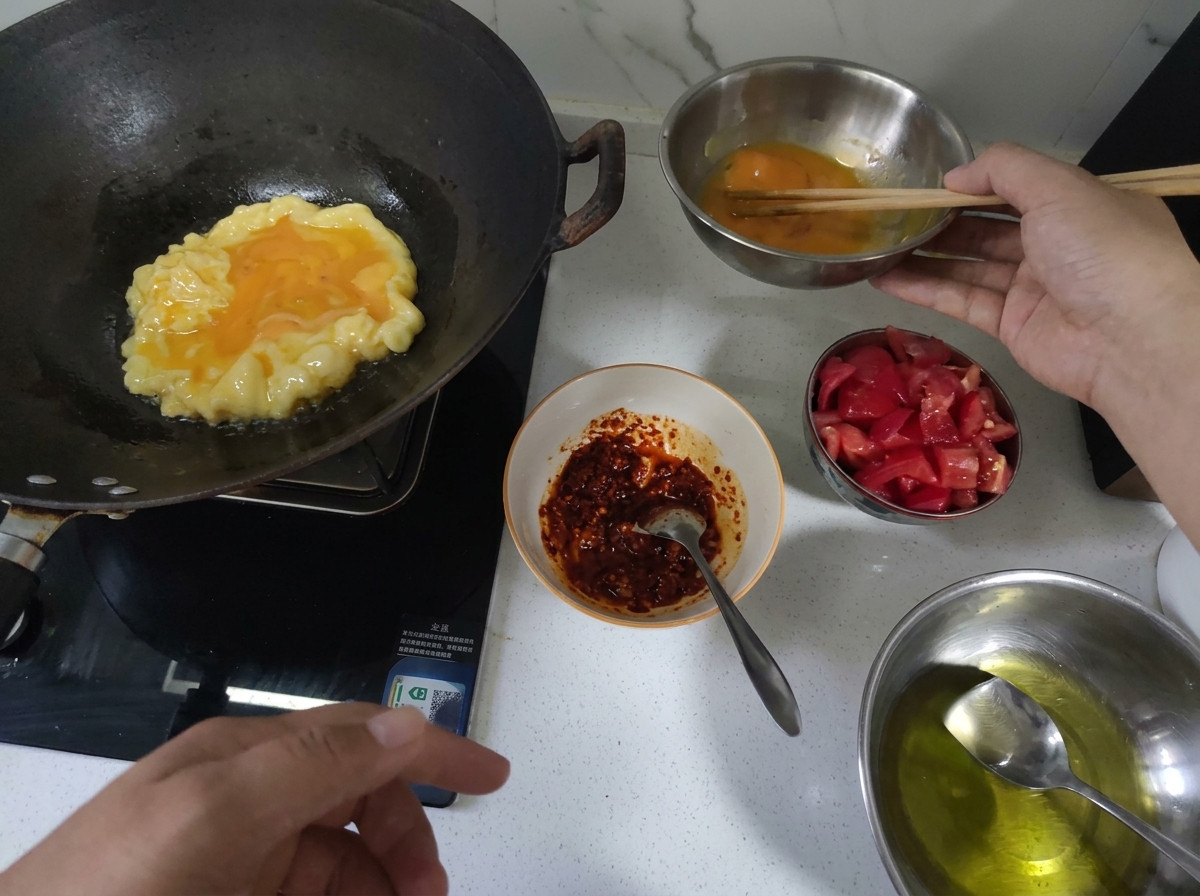 Eggs being scrambled in a hot wok until fluffy and golden.