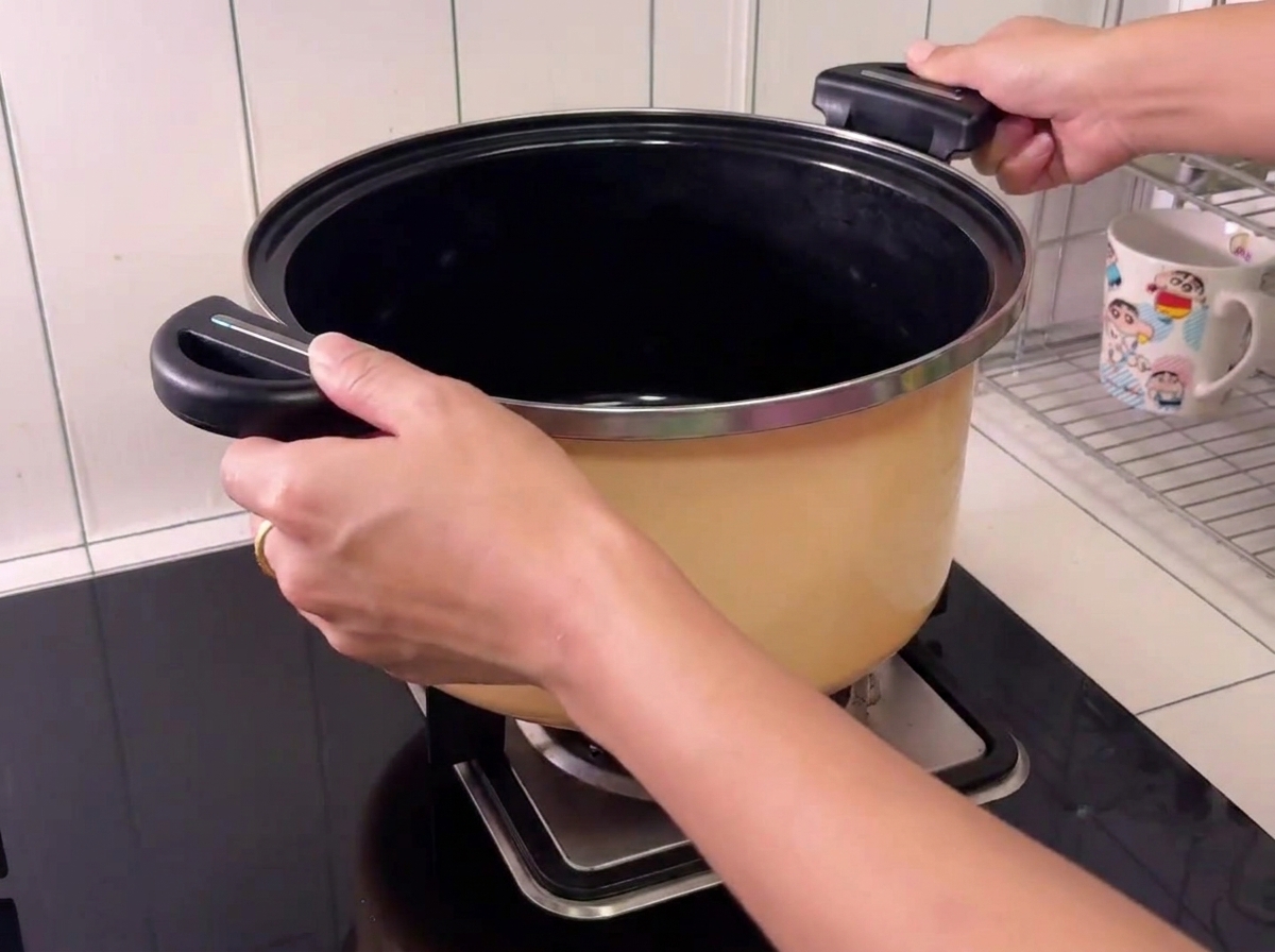Pork pieces inside a large pot with a bottle of cooking wine being added.