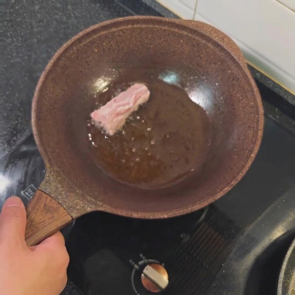 Pork ribs frying in hot oil until golden brown.