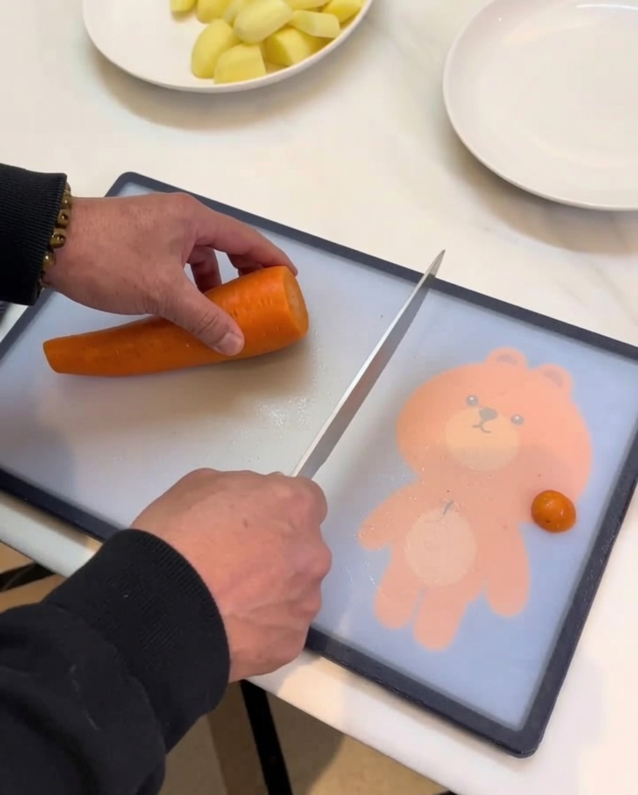 Carrots, potatoes, and other root vegetables being chopped into chunks on a cutting board.