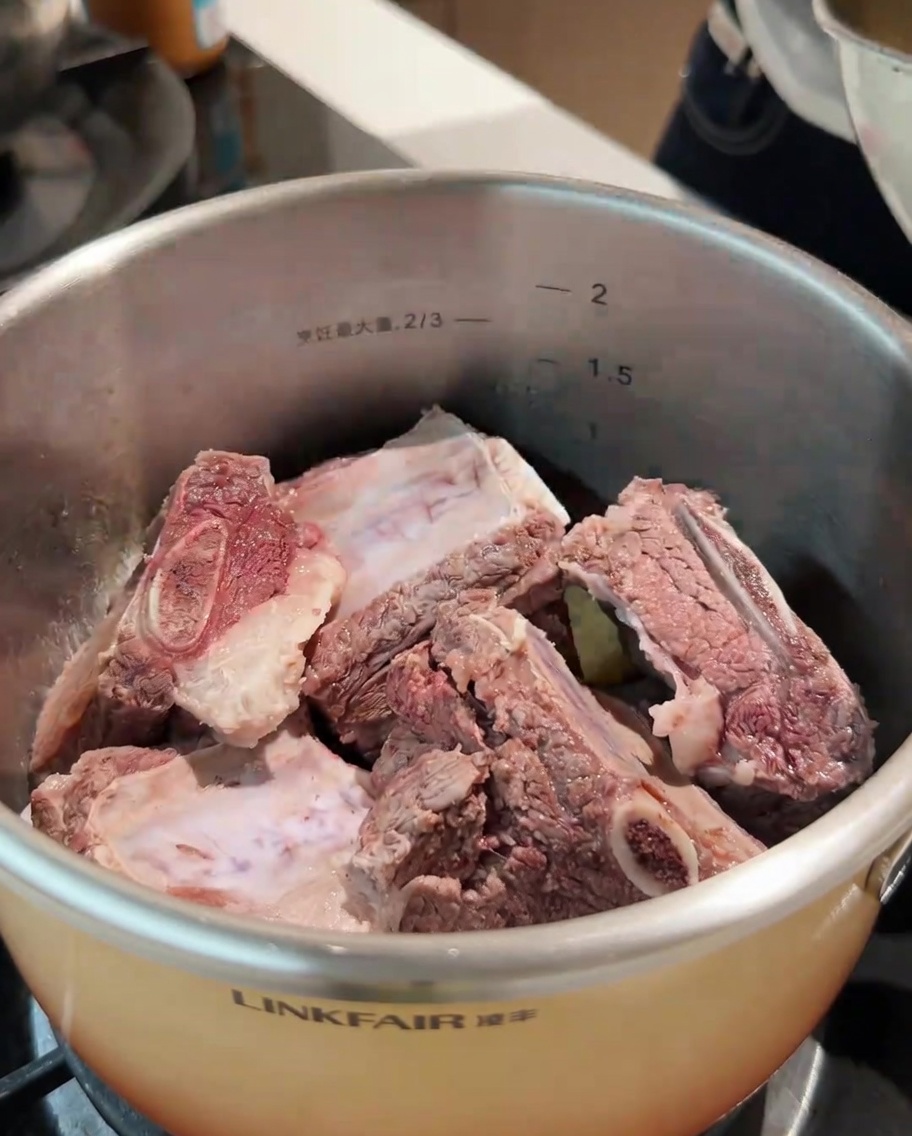 Blanched beef ribs and a variety of whole spices added to the pot.