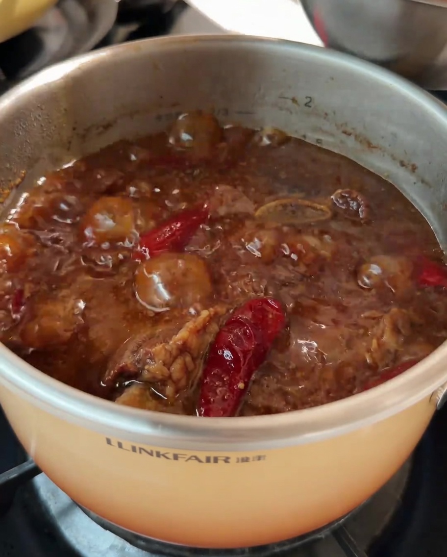 Chopped carrots being added to the pot of beef rib soup as it simmers.