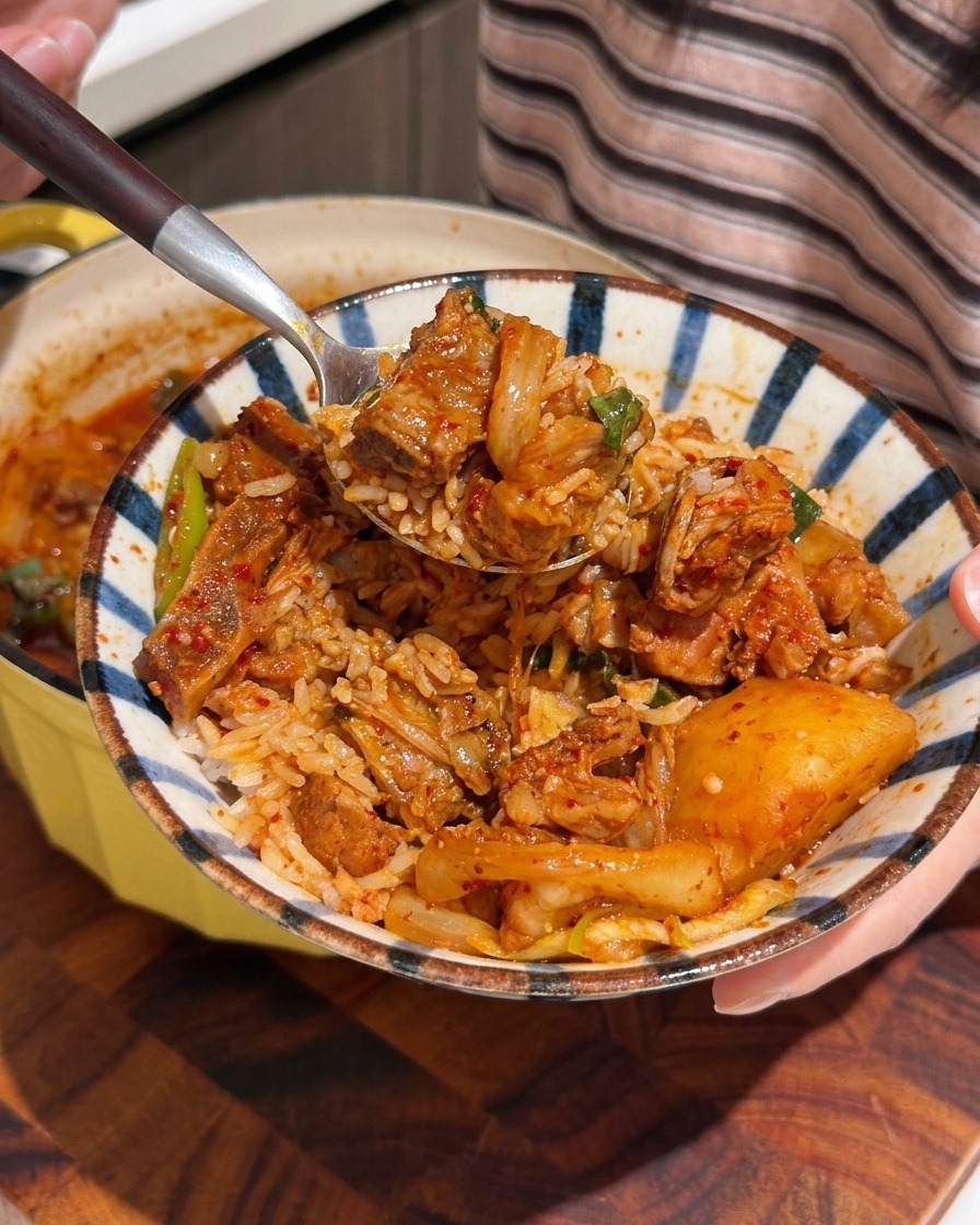 Pork spine pieces submerged in a large pot of cold water with aromatics.