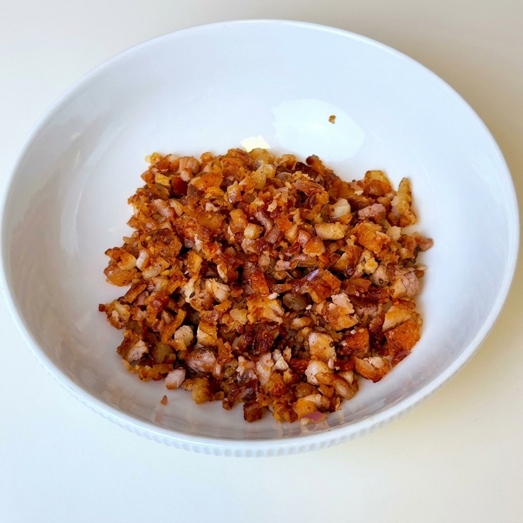 Finely chopped barbecue pork mixture resting inside a white bowl.