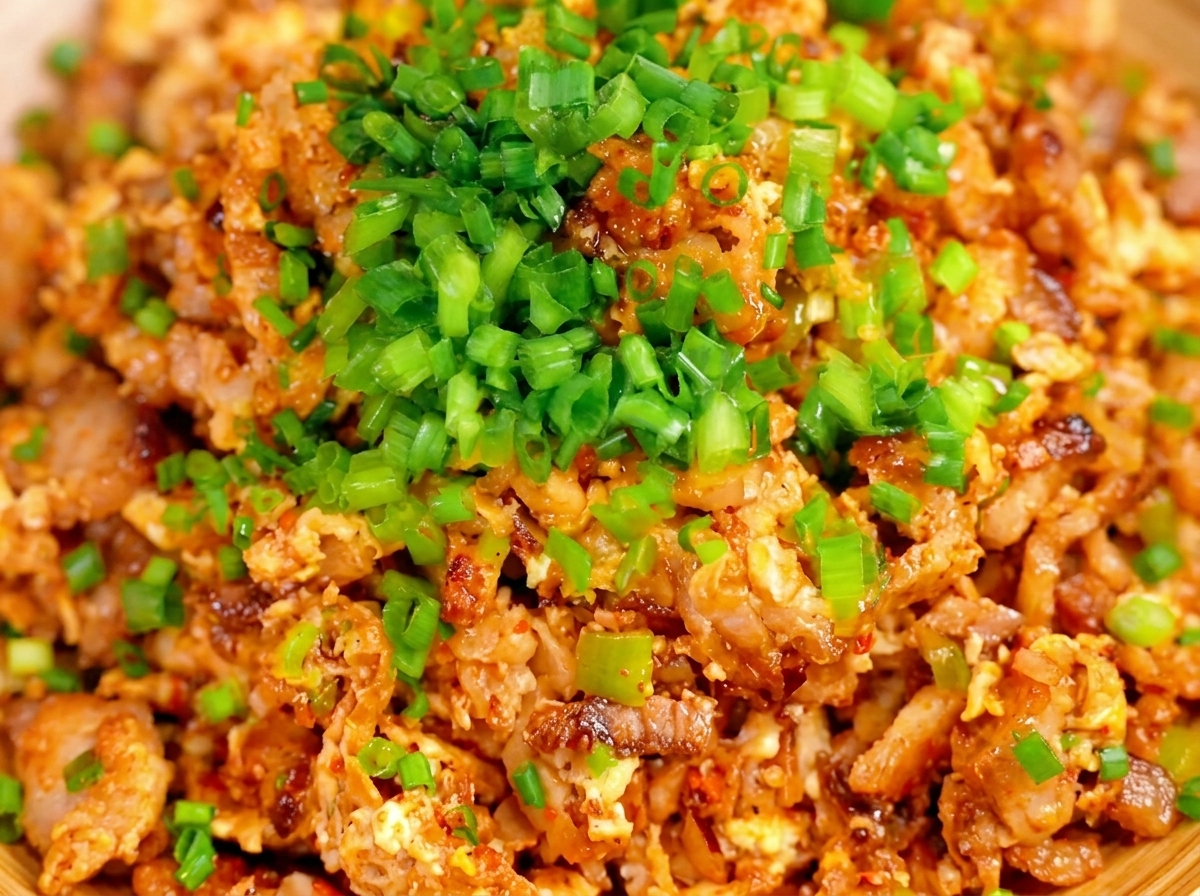 Close-up of the dumpling filling being mixed with chopsticks in a wooden bowl.
