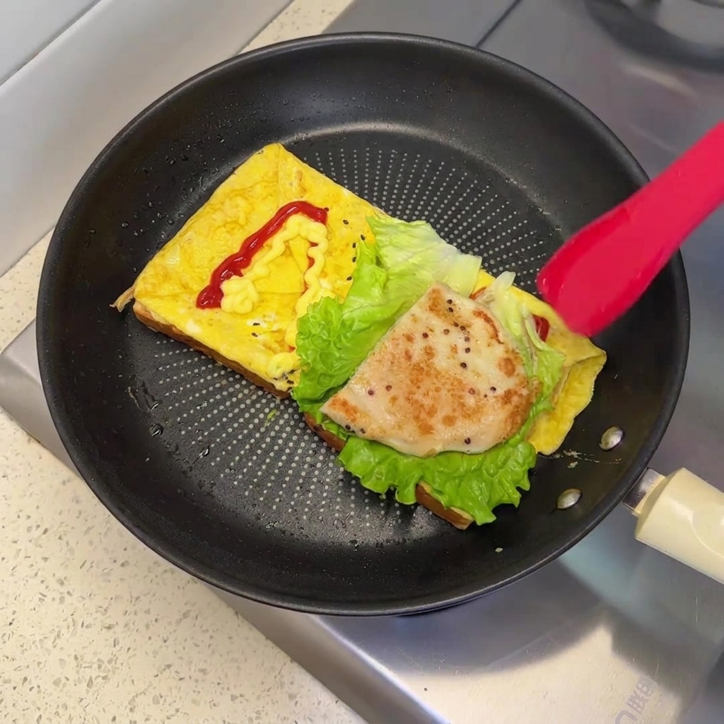 A golden-brown pan-fried chicken patty resting on top of the fresh lettuce inside the skillet.