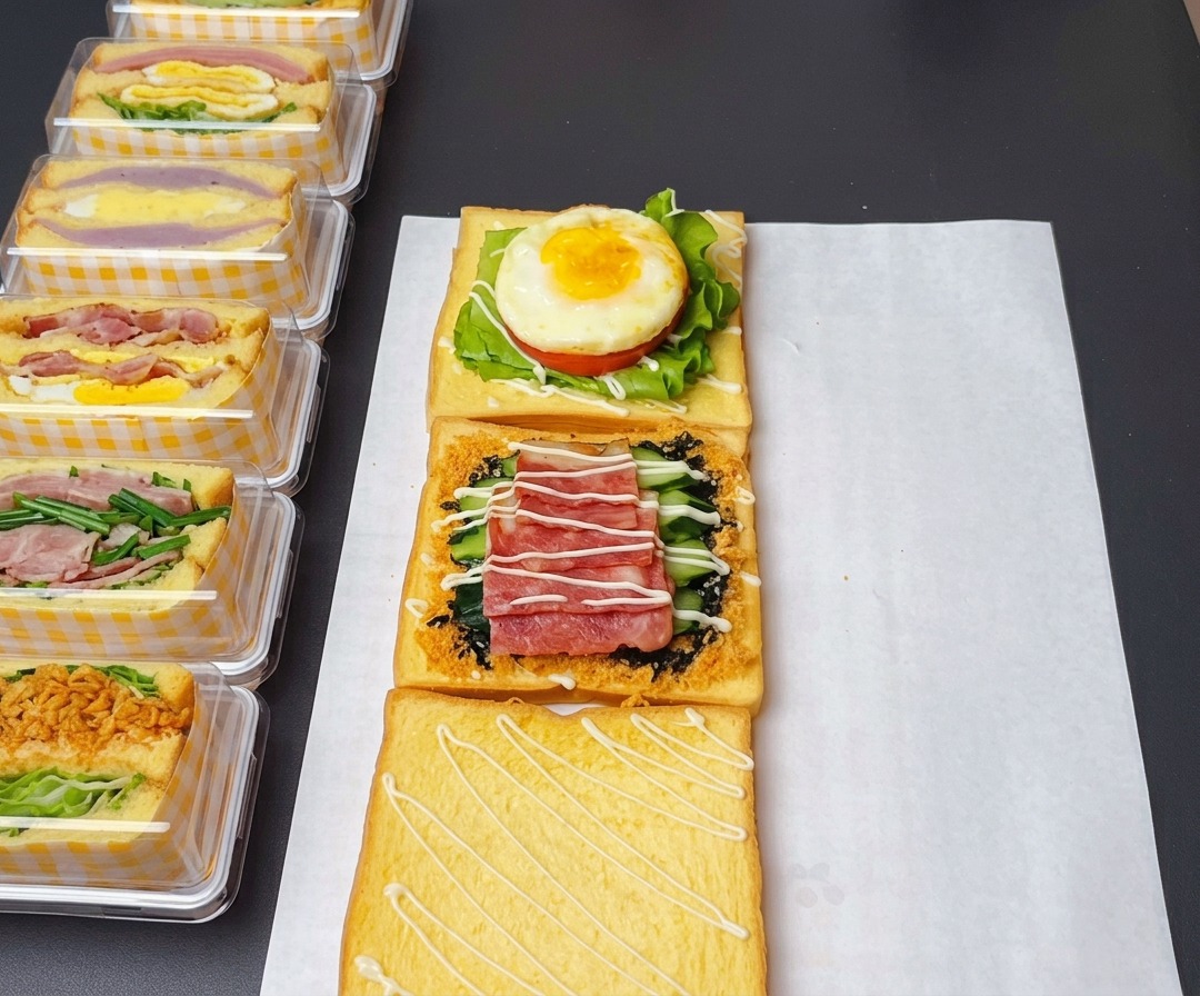 The assembled sandwich layers with sweet salad dressing, ketchup on the egg, and honey mustard sauce on the bacon.