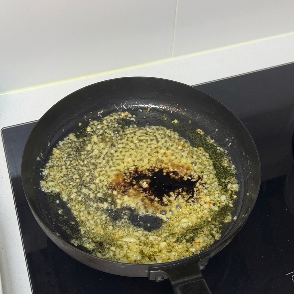 Oyster sauce being added to the sauce mixture in a frying pan.