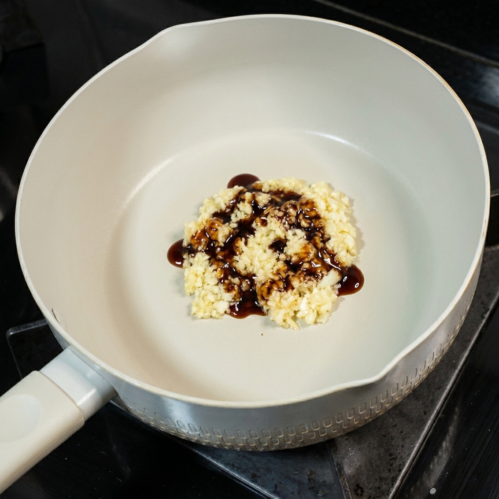 A small spoonful of sugar added to the garlic and soy sauce mixture in the pan.