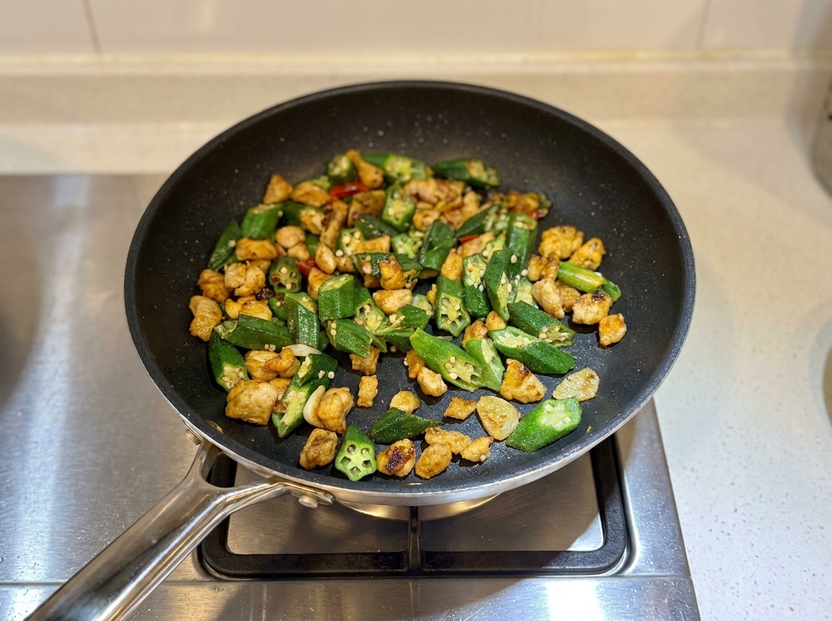 Finished chicken and okra stir-fry in the pan looking slightly dry and ready to serve.