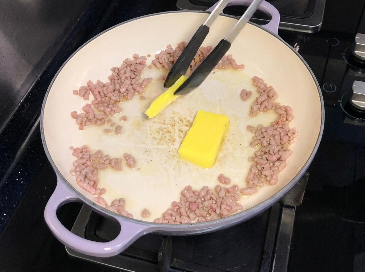 Butter being added and melted into a pan of browned minced porkcite: 1.