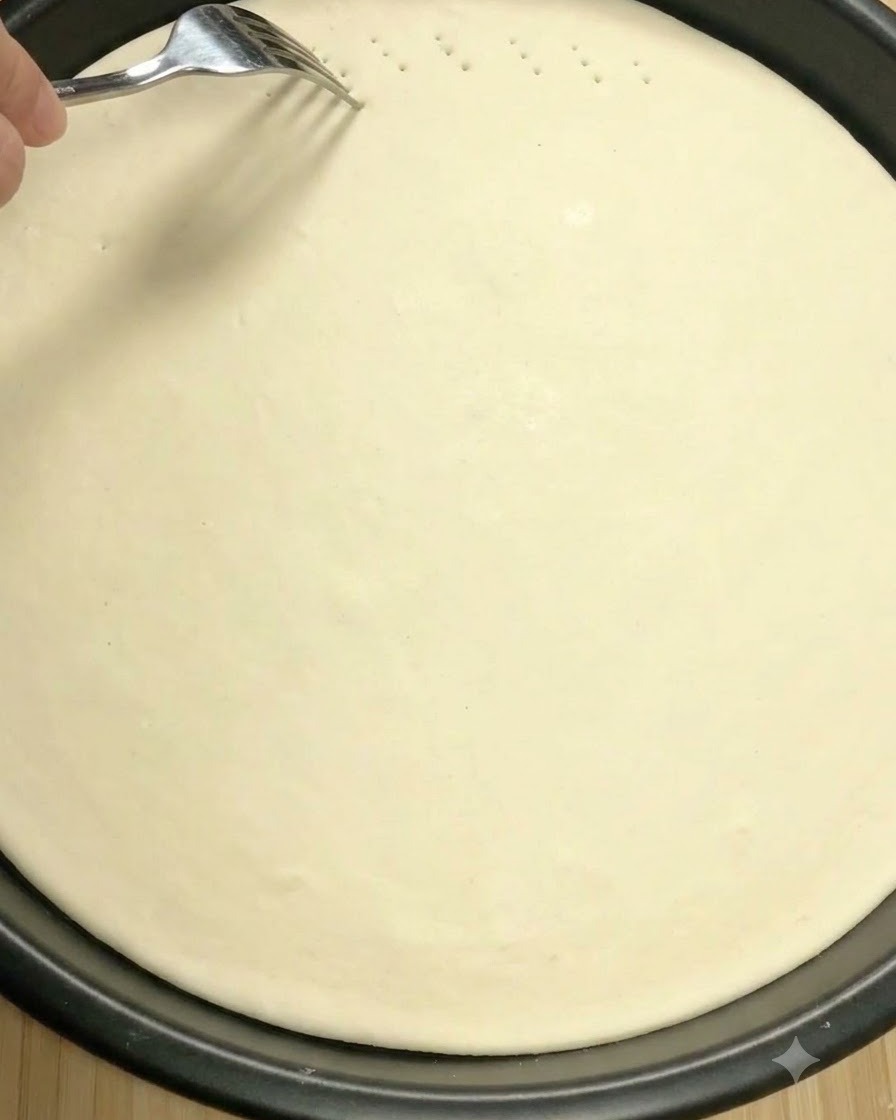 A metal fork poking small ventilation holes into the surface of raw pizza dough.