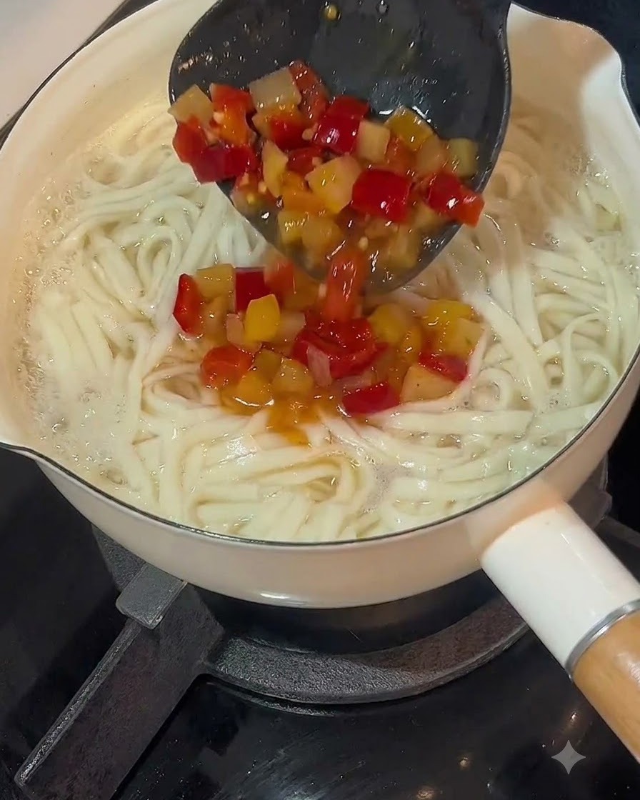 A ladle pouring pickled chili soup base over a pot of cooked noodles.