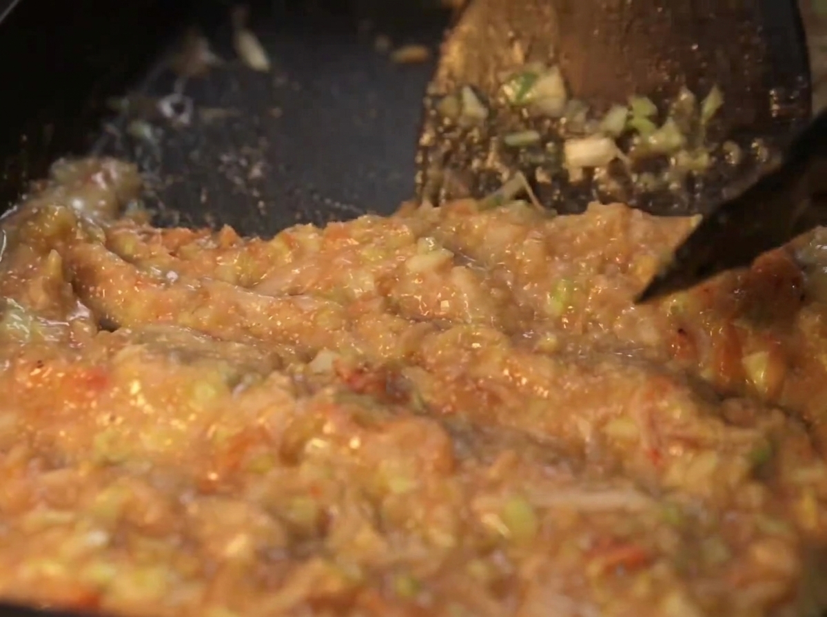 Thick monjayaki mixture spread flat across the black hot plate surface.