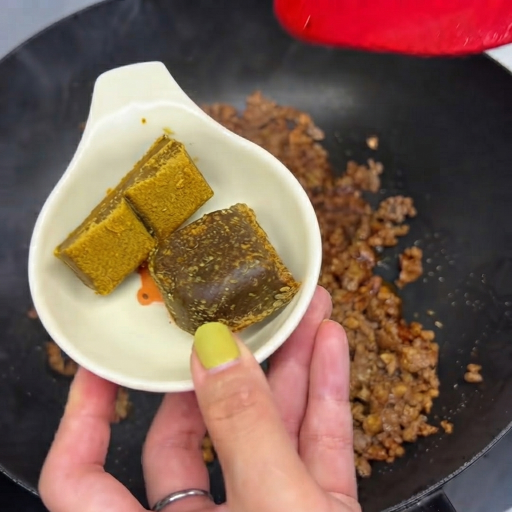 Two curry blocks held in a small white dish ready to be dropped into the pan with minced meat.