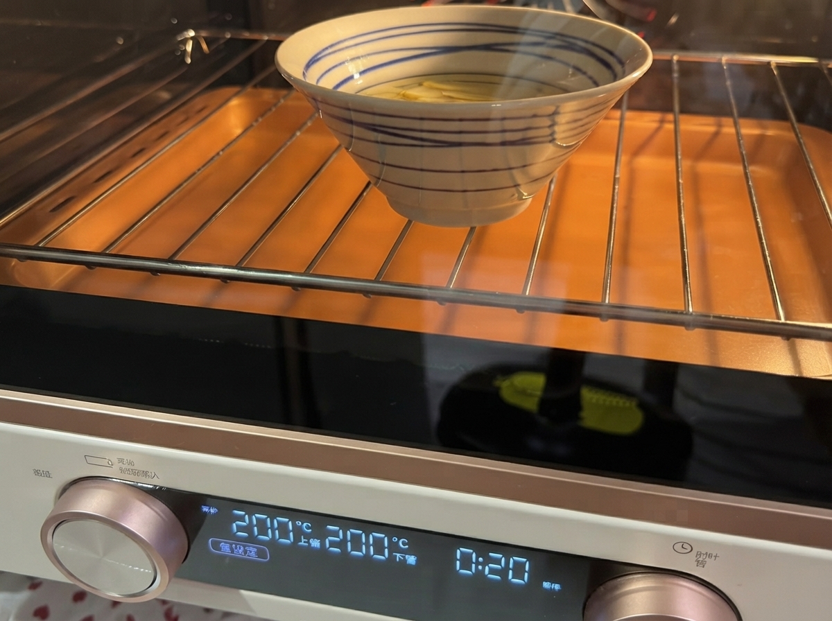 Slicing garlic in oil inside a bowl in a toaster oven.