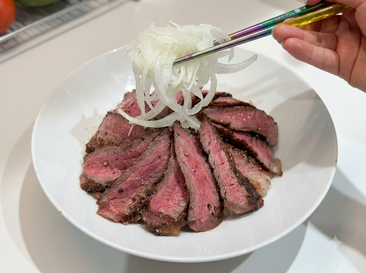 Shredded onions being placed onto the steak bowl with chopsticks.