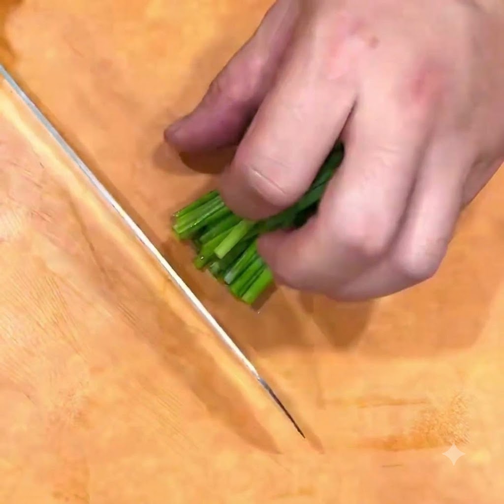 Green onions being chopped into scallion flower on a wooden board with a knife.