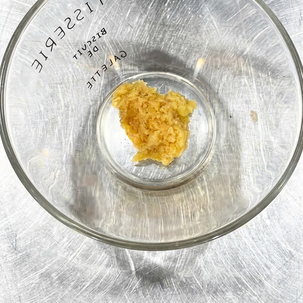Minced garlic sauce in a clear glass bowl.