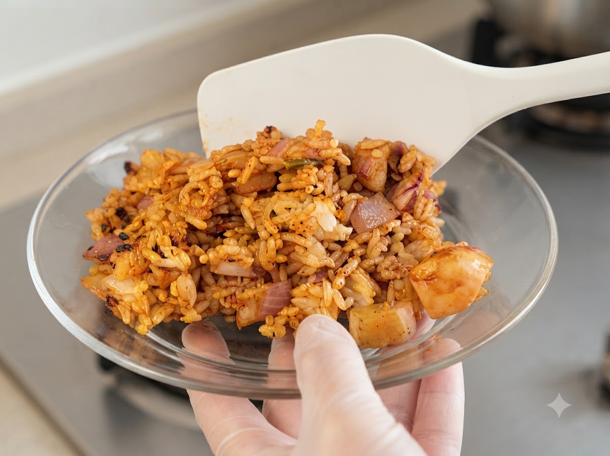 Chopped red onions and minced garlic being added to the pan with the chicken.
