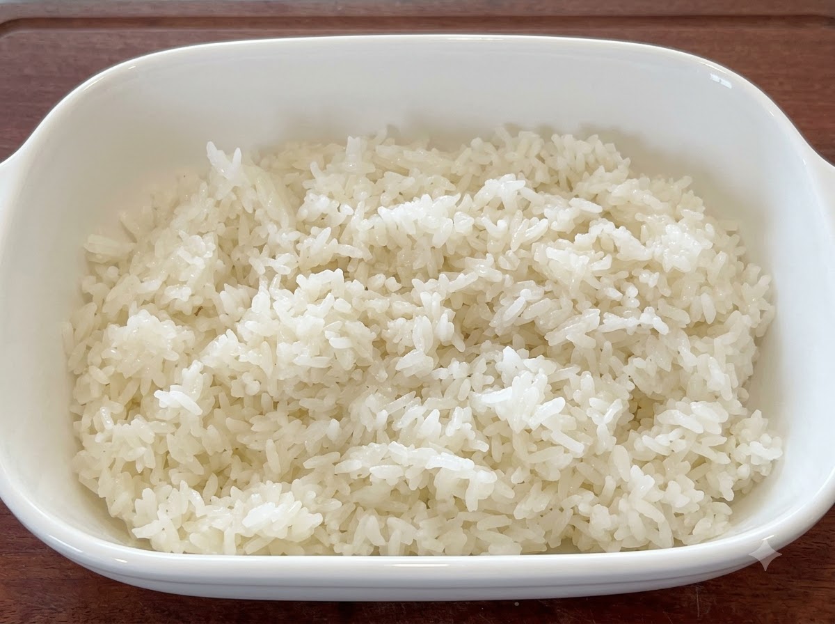 Fresh white rice mixed with sesame seeds and oil in a white serving dish.