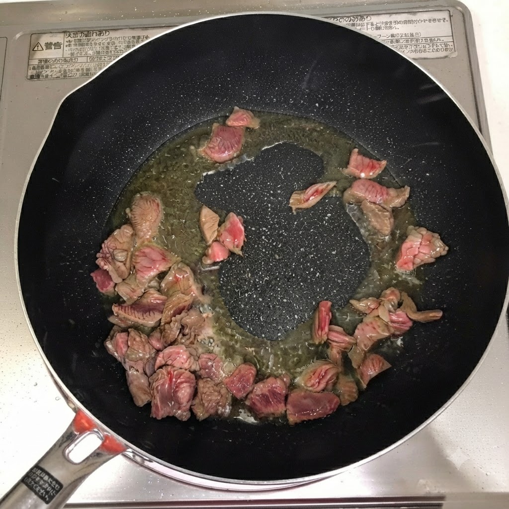 Cooking wine, chili powder, and chili paste added over the beef in the pan.