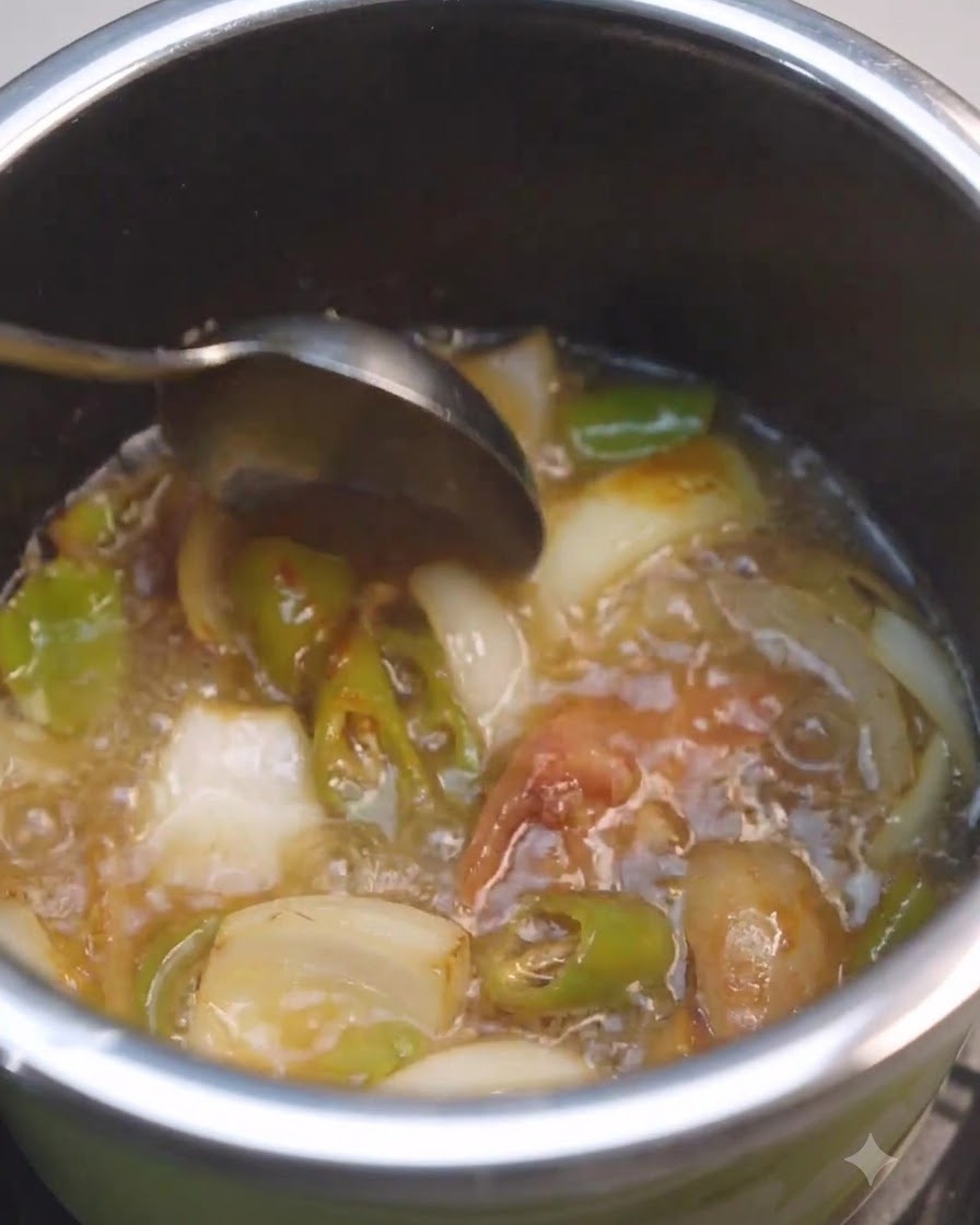A spoon stirring liquid and soybean paste inside a pot with vegetables.