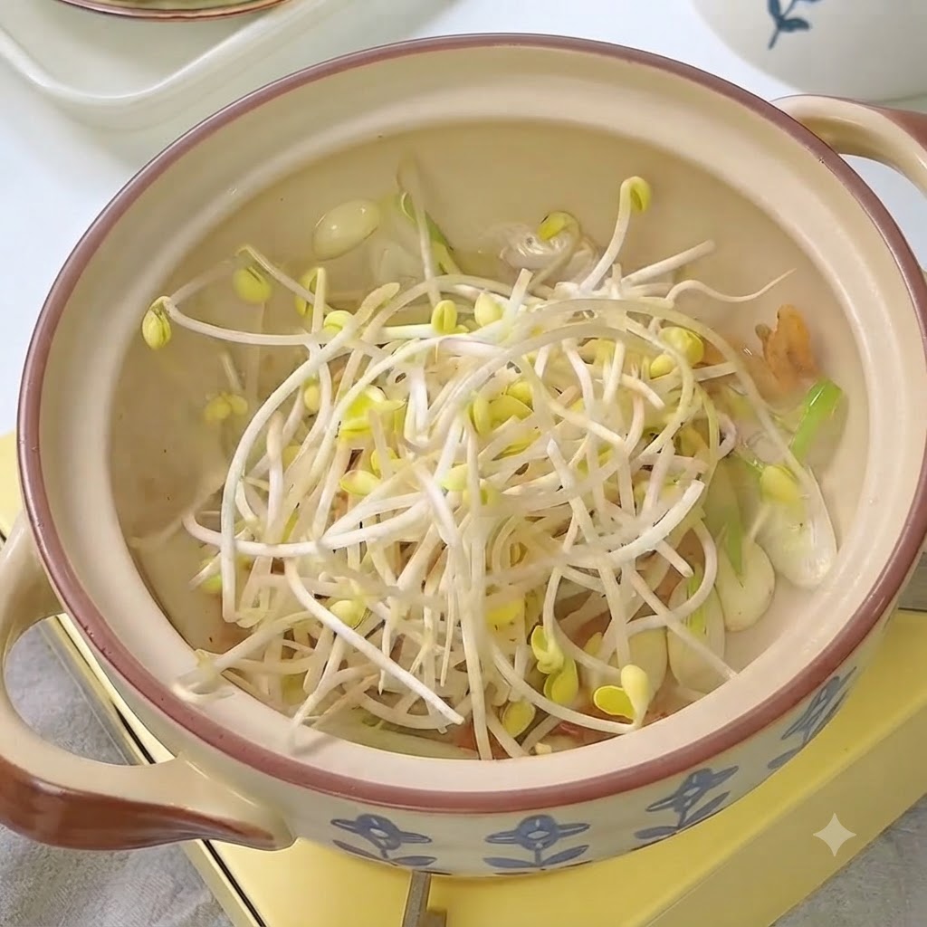Fresh bean sprouts placed in the pot with kimchi and aromatics.