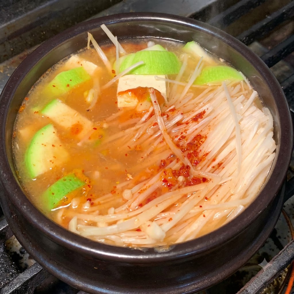 A close-up of the earthenware pot with ingredients simmering in a seasoned broth.