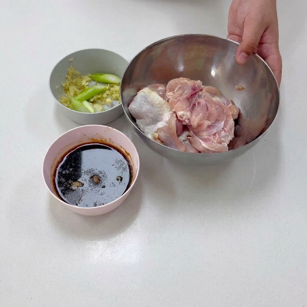 Boneless chicken thigh meat resting inside a stainless steel bowl during preparation.