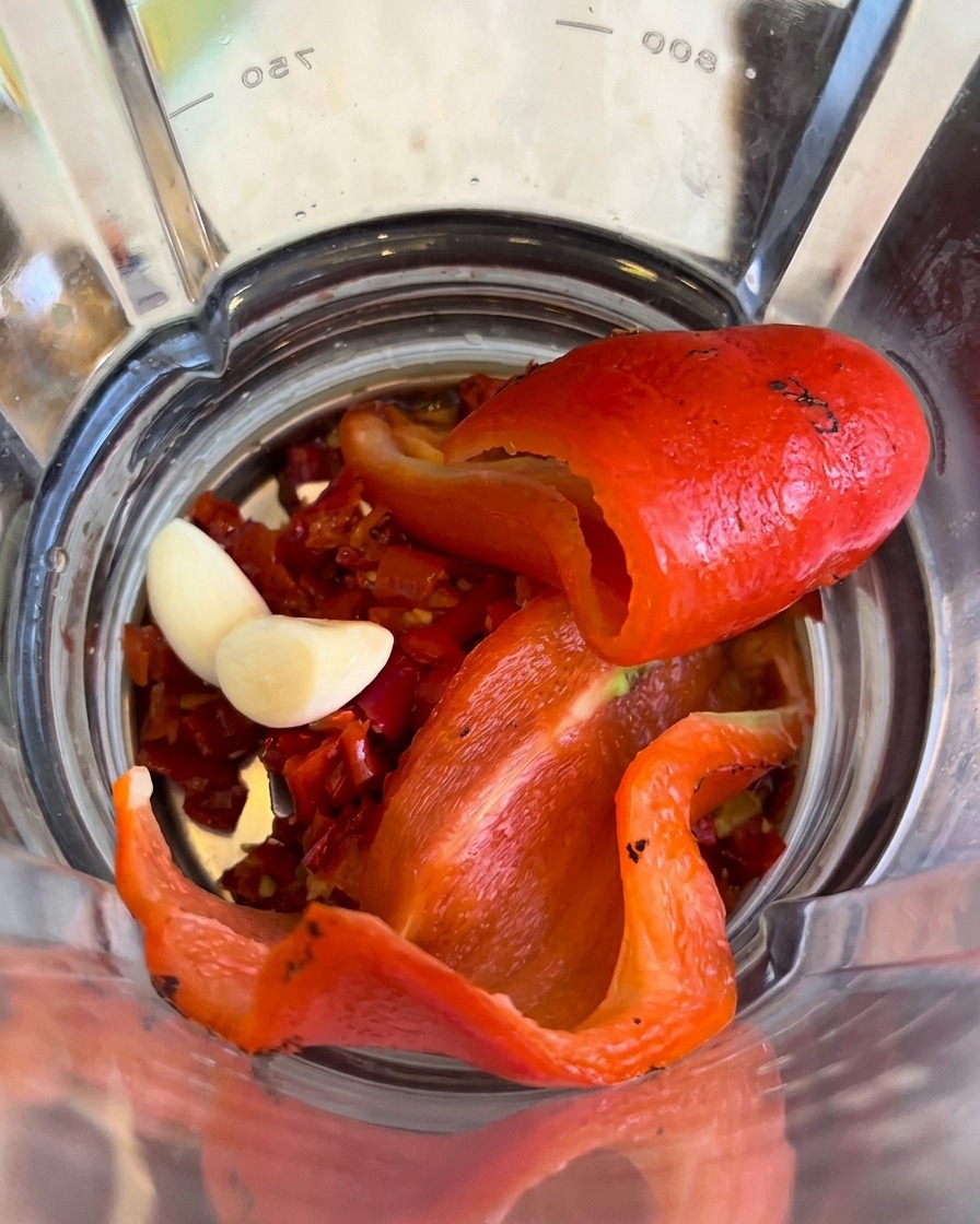 Black truffle seasoning added to the peppers and garlic inside the blender.